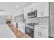 Kitchen features white cabinetry, stainless steel appliances, and marble backsplash at 1842 Oklahoma Ne Ave, St Petersburg, FL 33703