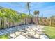 Charming outdoor patio with stone pavers, wood fence, decorative pergola and lush tropical greenery at 1842 Oklahoma Ne Ave, St Petersburg, FL 33703