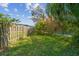 Grassy backyard bordered by a wood fence and mature trees, providing a private and tranquil outdoor space at 2114 Fawn Meadow Dr, Valrico, FL 33594