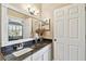 Bright bathroom with granite countertop, a white sink, and a framed mirror at 2114 Fawn Meadow Dr, Valrico, FL 33594