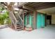 Exterior of home featuring an outdoor staircase, turquoise siding, and tropical landscaping at 2504 Avenue B # A, Bradenton Beach, FL 34217