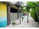 Exterior of home featuring a privacy fence, tropical landscaping, and sand-colored pebble ground cover at 2504 Avenue B # A, Bradenton Beach, FL 34217