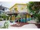 Side view of colorful beach house featuring a sun deck and tropical landscaping at 2504 Avenue B # A, Bradenton Beach, FL 34217