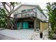 Two-story home with elevated sundeck, surrounded by mature trees and tropical plants at 2504 Avenue B # A, Bradenton Beach, FL 34217