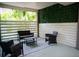 Comfortable outdoor patio featuring wicker furniture, a patterned rug, and a privacy fence with green vines at 2504 Avenue B # A, Bradenton Beach, FL 34217