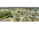 An aerial view showcases homes with manicured lawns in a golfing community with a pond at 29312 Marker Loop, San Antonio, FL 33576
