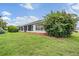 Backyard featuring a screened-in lanai, lush landscaping, and ample green space at 29312 Marker Loop, San Antonio, FL 33576