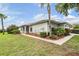 Inviting single-story home with manicured lawn, lush landscaping, and mature palm trees at 29312 Marker Loop, San Antonio, FL 33576
