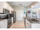 Well-equipped kitchen with stainless steel appliances, white cabinetry, and tile flooring at 29312 Marker Loop, San Antonio, FL 33576