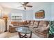 Comfortable living room featuring a large sectional sofa, a glass coffee table, and a ceiling fan at 29312 Marker Loop, San Antonio, FL 33576