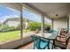 Screened patio with outdoor seating and a view of the backyard and neighboring houses at 29312 Marker Loop, San Antonio, FL 33576