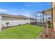 Back yard featuring a new fence, landscaping and a screened-in enclosure at 313 Old Windsor Way, Spring Hill, FL 34609