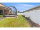 Back yard featuring a new fence, landscaping, and a screened patio at 313 Old Windsor Way, Spring Hill, FL 34609