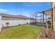 Back yard featuring a new fence, landscaping and a screened-in enclosure at 313 Old Windsor Way, Spring Hill, FL 34609