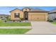 Charming one-story home boasts a two-car garage, meticulously landscaped front yard, and neutral-toned exterior at 313 Old Windsor Way, Spring Hill, FL 34609