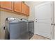 Laundry room featuring front load washer and dryer with overhead storage cabinets at 313 Old Windsor Way, Spring Hill, FL 34609