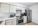 Functional kitchen with stainless steel appliances and white cabinetry offers ample storage space at 3350 Mermoor Dr # 1201, Palm Harbor, FL 34685