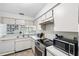 Bright kitchen with white appliances, tiled floor and ample natural light at 3350 Mermoor Dr # 1201, Palm Harbor, FL 34685