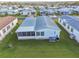 An aerial view displays a cozy home with a screened lanai, lush lawn, and meticulous landscaping at 37545 Lilly Bea Ave, Zephyrhills, FL 33541