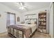 Cozy bedroom featuring a comfortable bed, ceiling fan, window and bookshelf at 37545 Lilly Bea Ave, Zephyrhills, FL 33541