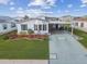 Charming single-story home features a well-manicured lawn, carport, and vibrant landscaping with colorful flowers at 37545 Lilly Bea Ave, Zephyrhills, FL 33541