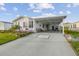 Charming single-story home features a well-manicured lawn, carport, and vibrant landscaping with colorful flowers at 37545 Lilly Bea Ave, Zephyrhills, FL 33541