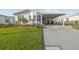 Charming single-story home features a well-manicured lawn, carport, and vibrant landscaping with colorful flowers at 37545 Lilly Bea Ave, Zephyrhills, FL 33541