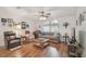 Bright living room with hardwood floors, multiple seating options, and a ceiling fan at 37545 Lilly Bea Ave, Zephyrhills, FL 33541