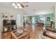 Open-concept living room flows into dining area, featuring wood floors and a ceiling fan at 37545 Lilly Bea Ave, Zephyrhills, FL 33541