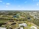 Wide aerial perspective of the golf course community with winding fairways and multiple ponds at 3829 Trophy Blvd, New Port Richey, FL 34655