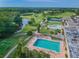 This aerial view showcases community pools, tennis courts and a scenic golf course surrounded by mature trees at 3829 Trophy Blvd, New Port Richey, FL 34655