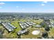 Expansive aerial view of the community showcasing the golf course and well-maintained residences under a bright sky at 3829 Trophy Blvd, New Port Richey, FL 34655
