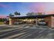 Exterior view showcasing a covered parking area with ample space for multiple vehicles against a beautiful sunset at 3829 Trophy Blvd, New Port Richey, FL 34655