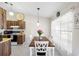 Dining area adjacent to the kitchen, featuring modern lighting and a view of the backyard through sheer curtains at 3904 36Th Avenue W Dr, Bradenton, FL 34205