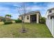 Inviting backyard featuring a screened patio, lush landscaping, and white picket fence at 407 Sandsend Ct, Apollo Beach, FL 33572