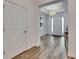 Bright entryway featuring wood-look tile floors and a modern chandelier, leading to a white front door at 407 Sandsend Ct, Apollo Beach, FL 33572