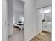 Hallway view to a bedroom with white interior and a bathroom with a vanity and tile flooring at 407 Sandsend Ct, Apollo Beach, FL 33572