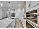 Modern kitchen with stainless steel appliances, white cabinetry, and a spacious island with quartz countertops at 407 Sandsend Ct, Apollo Beach, FL 33572