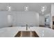 Close up of the large kitchen island with a stainless steel sink and modern faucet at 407 Sandsend Ct, Apollo Beach, FL 33572