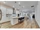 Open-concept kitchen featuring a large island with pendant lighting, white cabinets, and stainless steel appliances at 407 Sandsend Ct, Apollo Beach, FL 33572