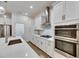 A modern, all white kitchen with stainless steel appliances and quartz countertops at 407 Sandsend Ct, Apollo Beach, FL 33572
