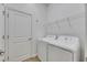 Bright laundry room with appliances and wire shelving at 407 Sandsend Ct, Apollo Beach, FL 33572