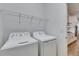 Well-lit laundry room featuring a washer, dryer, and wire shelving for optimal organization at 407 Sandsend Ct, Apollo Beach, FL 33572
