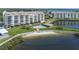 Waterfront condos showcasing a pool, beach access, and manicured lawn from an aerial perspective at 4650 Bay Blvd # 1012, Port Richey, FL 34668