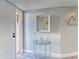 Condominium entrance with a glass table, mirror, and a beach themed sign at 4650 Bay Blvd # 1012, Port Richey, FL 34668