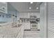 Bright kitchen with stainless steel appliances, white cabinets, and light granite countertops at 4650 Bay Blvd # 1012, Port Richey, FL 34668