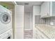 Convenient laundry area with stackable washer and dryer, and granite countertop with backsplash at 4650 Bay Blvd # 1012, Port Richey, FL 34668