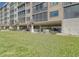 View of condo building parking with nearby grass and landscaping at 4650 Bay Blvd # 1012, Port Richey, FL 34668