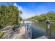 Waterfront property featuring a boat dock, with lush landscaping along the canal at 520 74Th St, Holmes Beach, FL 34217