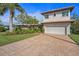 Beautiful home featuring a well-manicured lawn, charming landscaping, and a brick driveway at 520 74Th St, Holmes Beach, FL 34217